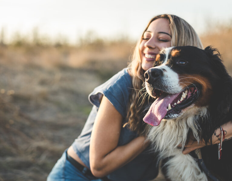 Eine Frau umarmt ihren Hund.