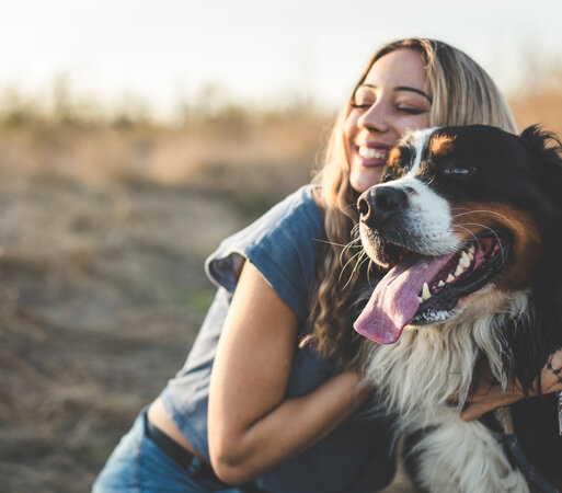 Eine Frau umarmt ihren Hund.
